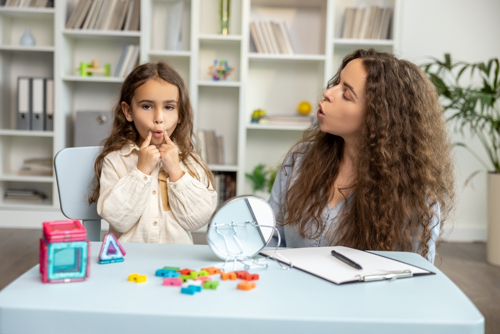 Girl sitting attable with teacher